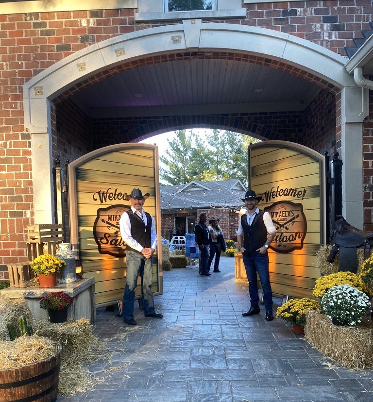 Two greeters stand by the entrance to the party